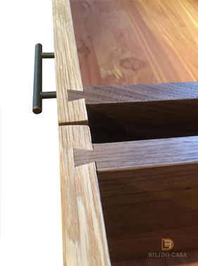 Close-up of custom wooden furniture’s handle and panel, showcasing craftsmanship in hardware integration.